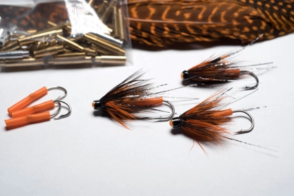 Orange fly tied on a brass tube Orange fly tied on a brass tube