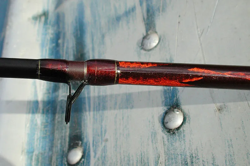 Filament what? - The butt of this rod is reinforced with an additional cross-wrapped 'sleeve' so to say, for additional oomph and lifting power. The contrast between the matte burgundy blank and the glossy cross-wrapped butt makes for a nice visual touch. Oh, by the way, the jonboat ain't mine; I use a Mad River Canoe...